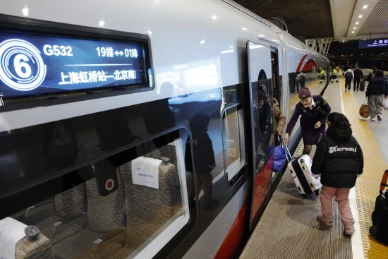 上海虹桥至北京南的G532次高铁列车长徐佩佩在站台上帮助旅客上车。中新网记者 殷立勤 摄 上海虹桥至北京南的G532次高铁列车长徐佩佩在站台上帮助旅客上车。中新网记者 殷立勤 摄