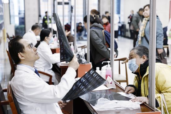 骨科中心运动医学科主任陈疾忤查看市民CT影像片子。中新网记者 殷立勤 摄 骨科中心运动医学科主任陈疾忤查看市民CT影像片子。中新网记者 殷立勤 摄