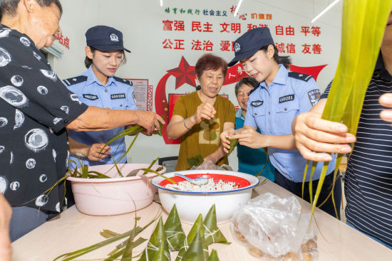 民警与村民们一起包粽子,迎接端午佳节。沈群 摄 民警与村民们一起包粽子,迎接端午佳节。沈群 摄