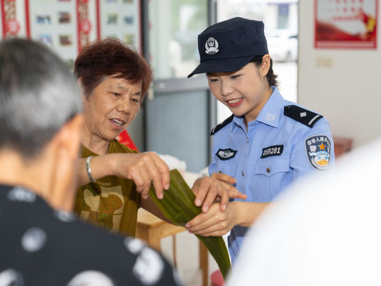 民警与村民们一起包粽子,迎接端午佳节。沈群 摄 民警与村民们一起包粽子,迎接端午佳节。沈群 摄