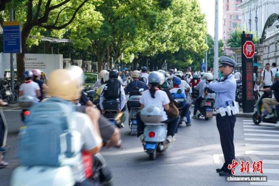 上海市公安局闵行公安分局交警支队民警在临近莘光学校附近的雅致路雅怡路路口疏导送学车辆通行。上海市公安局闵行分局供图 上海市公安局闵行公安分局交警支队民警在临近莘光学校附近的雅致路雅怡路路口疏导送学车辆通行。上海市公安局闵行分局供图