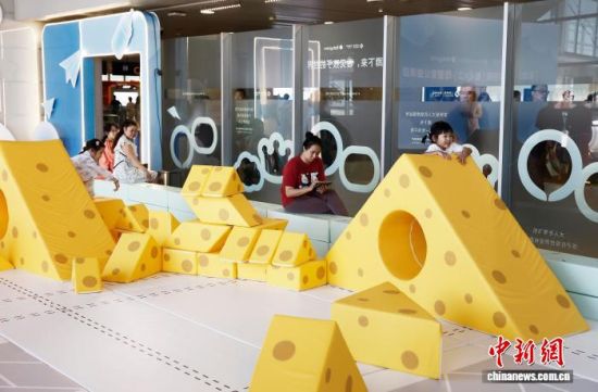 旅客陪伴孩子在浦东国际机场T2航站楼内玩耍。中新网记者 殷立勤 摄 旅客陪伴孩子在浦东国际机场T2航站楼内玩耍。中新网记者 殷立勤 摄