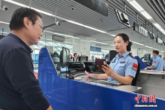 边检工作人员为民众办理手续。(上海边检总站供图) 边检工作人员为民众办理手续。(上海边检总站供图)