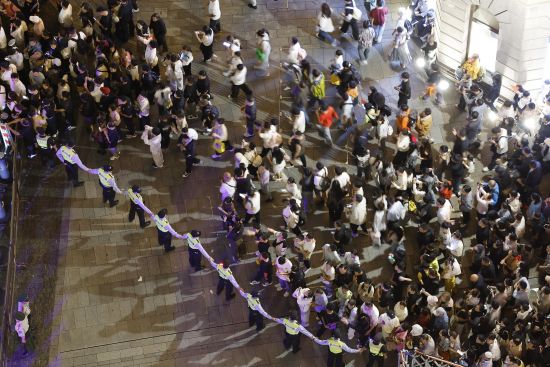 黄浦民警引导游客有序上下江堤。中新网记者 殷立勤 摄 黄浦民警引导游客有序上下江堤。中新网记者 殷立勤 摄
