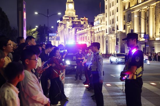 黄浦民警引导游客有序上下江堤。中新网记者 殷立勤 摄 黄浦民警引导游客有序上下江堤。中新网记者 殷立勤 摄