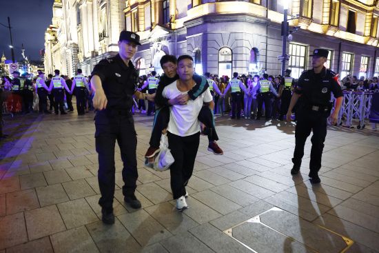 黄浦特警帮助老人游客有序离开管控区域。中新网记者 殷立勤 摄 黄浦特警帮助老人游客有序离开管控区域。中新网记者 殷立勤 摄