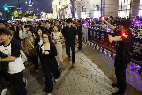 黄浦特警引导游客有序前往江堤。中新网记者 殷立勤 摄 黄浦特警引导游客有序前往江堤。中新网记者 殷立勤 摄