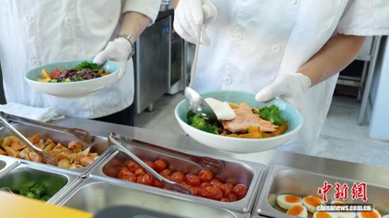 10月14日,上海龙南家园社区食堂里,工作人员正在为居民准备健康轻食餐。娄瀚锟 摄 10月14日,上海龙南家园社区食堂里,工作人员正在为居民准备健康轻食餐。娄瀚锟 摄